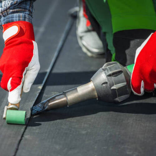 worker installing EPDM roofing