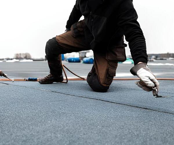 worker installing modified bitumen roofing